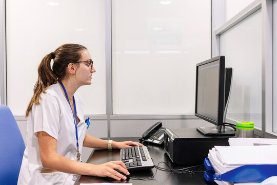 Healthcare professional working on computer at pharmacy