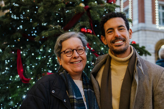 Mother and adult son smiling during Christmas holiday outdoors