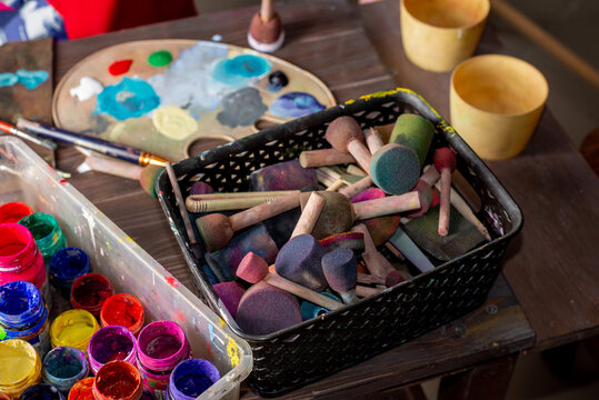 Artist brushes, paint cans and a palette with mixed paints