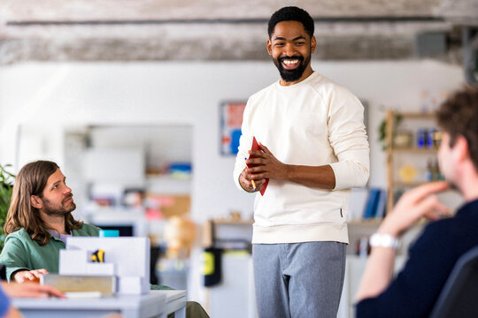 Friendly Businessman Engages Team During Casual Meeting