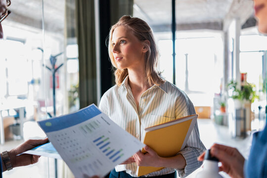 Professional Woman Discussing Documents in Office