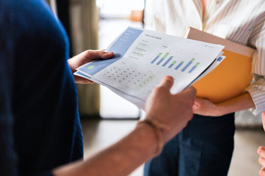 Business Team Reviewing Documents And Graphs In Office