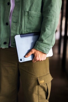 Person With Tablet In Green Jacket And Cargo Pants