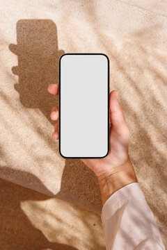 Phone mockup with white screen in sunny outdoor setting