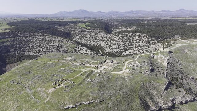 Cinematic aerial drone video footage of Blaundus Ancient City near Ulubey in Usak, Turkey, featuring ancient ruins, stone structures, and dramatic landscape from above in the Aegean region.