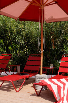 Red lounge chairs and umbrella on sunny patio