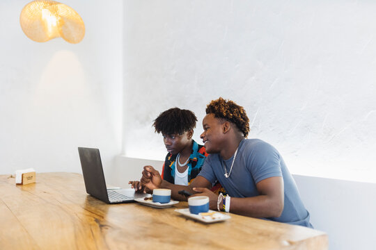 African men watching laptop screen in a cafe