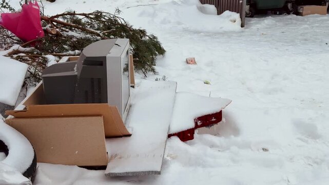 Old CRT Television Abandoned On Snow, Covered Pallet And Cardboard Amid Roadside Debris, Frost tipped Screen, Weathered Plastic And Rusted Metal, Bleak Winter Landscape, Melancholic Solitude.