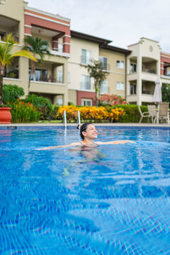 Smiling Person Enjoying A Swim In A Hotel Pool