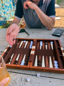 Man playing game of backgammon rolls his dice