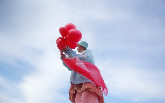 A woman with the pink ballons 