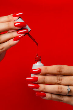 Vertical Shot Of Viscous Red Nail Polish Dripping From Brush