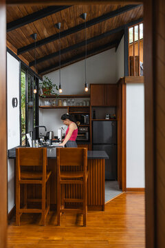 Woman Cooking In Contemporary Modern Kitchen With High Ceilings