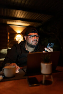 Professional Man Checking Smartphone During Late Night Work Session