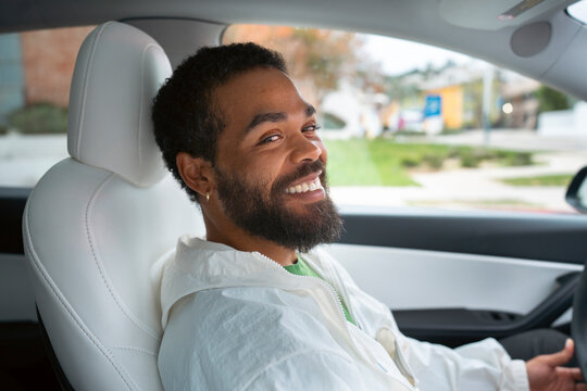 Man smiles while inside a car
