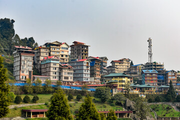 Fototapeta premium Colorful hillside town with multi-story buildings and scenic mountain surroundings in Sikkim. 