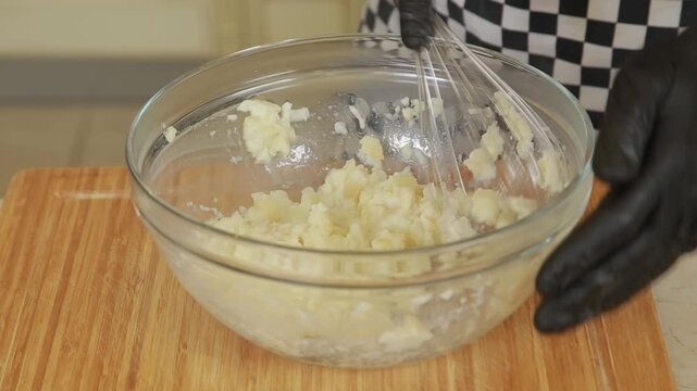 Professional chef mashing baked celery root while making puree