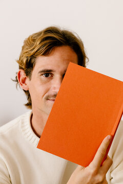 Portrait of a man posing cheerfully while covering half of his facce