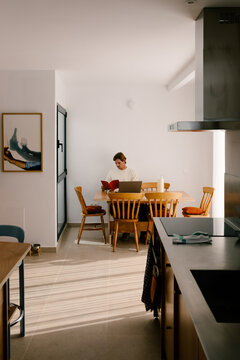 Wide-angle shot of remote worker using a laptop to work from home