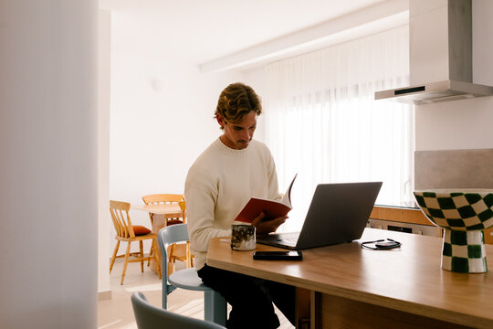 Young man working remotely on a laptop from modern home