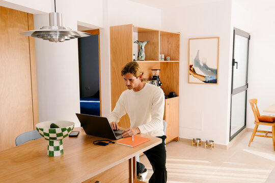 Modern man working remotely in his living room