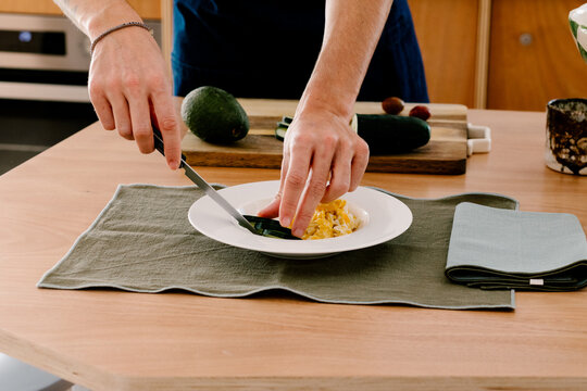 Unknown modern man preparing breakfast in a contemporary kitchen