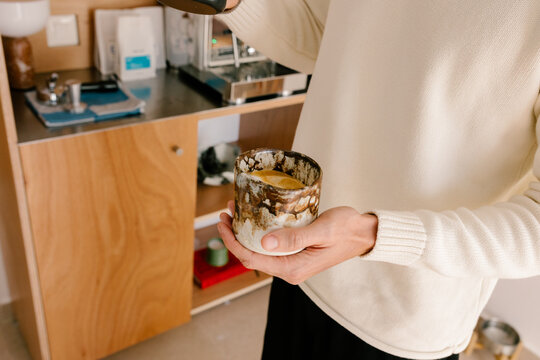 Anonymous man holding a handmade ceramic cup with coffee