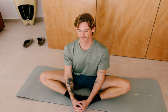 Modern man practicing yoga in a contemporary apartment
