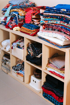 Colorful Fabric Collection Displayed on a Wooden Shelf
