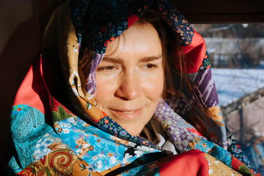 Woman Adorned in Vibrant Fabrics Shares a Warm Smile Indoors