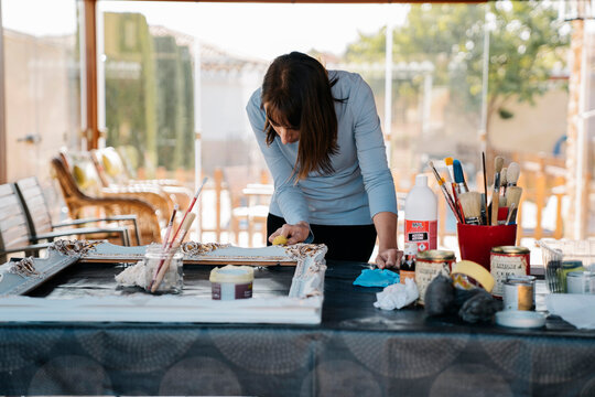 woman restoring vintage picture frame