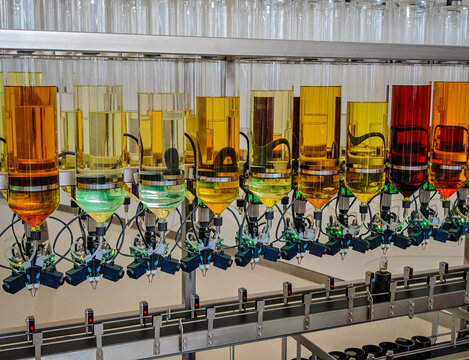 Perfume production. Different scents in bottles. Robotic perfume production line with automated fragrance dispensing 