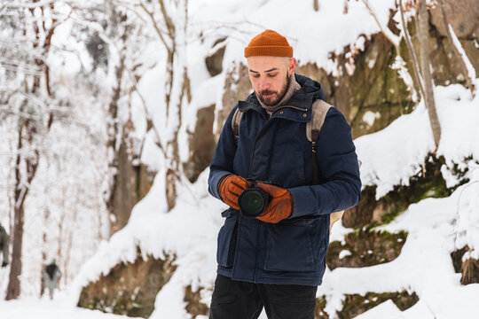 Professional photographer capturing winter landscape in snowy forest