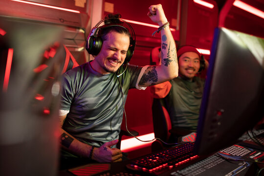 Competitive gamers celebrating victory at esports arena
