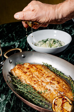 Squeezing lemon over fish