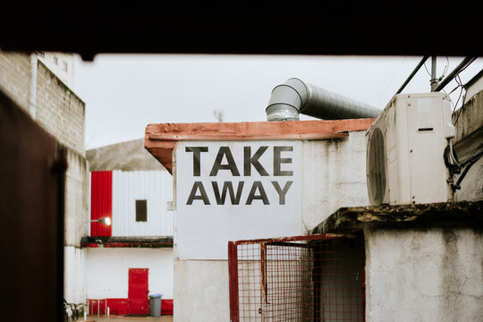 Take away sign on weathered building wall
