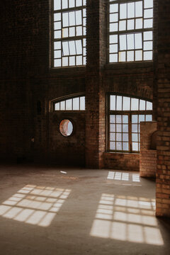 Sunlit industrial interior with brick walls and large windows