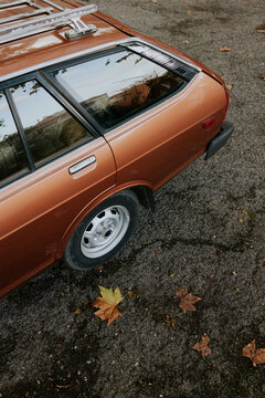 Classic orange car on autumn foliage background