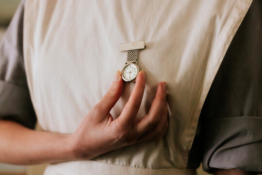 Close-up of a hand holding a pocket watch on fabric