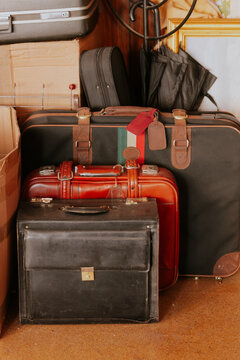 Vintage suitcases stacked for storage in a wooden closet