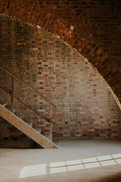 Rustic brick wall with wooden staircase and shadows