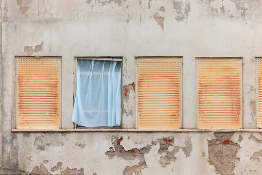 Weathered building facade with rusted shutters