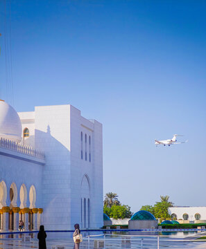 Private jet landing at Al Bateen Executive Airport in front of Sheikh Zayed Grand Mosque in Abu Dhabi