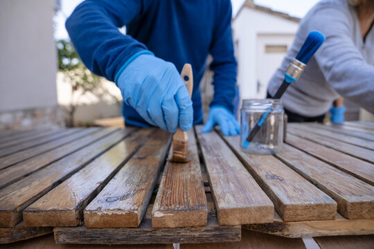 Senior restoring wooden tables