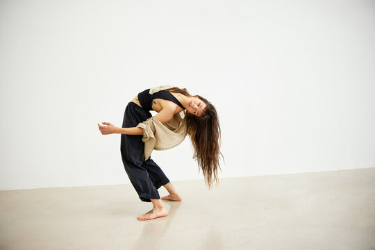 Dancer performs expressive movement in studio setting