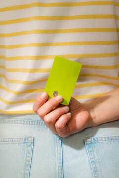 Green bank card behind back 