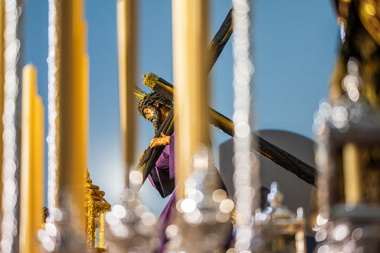 Christ of Gran Poder viewed through candles, canopy poles of palio float