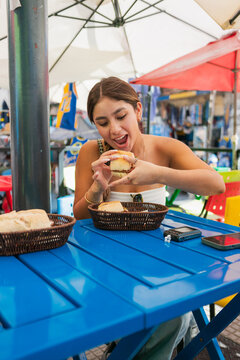 Woman eating Choripan in Caminito Buenos Aires