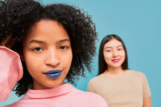 Confident woman with blue lipstick and friend in background