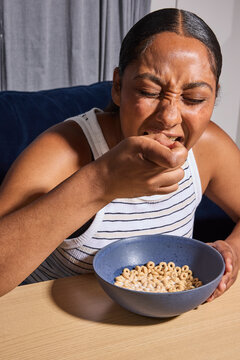 Woman sitting on couch eating her breakfast